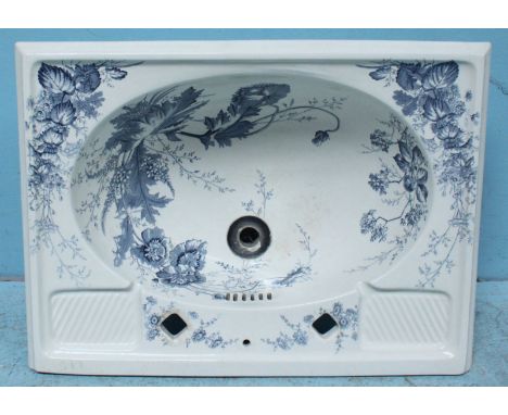 A blue and white floral printed wash basin with square tap holes