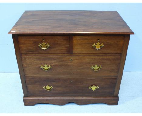 A walnut chest of two short over two long drawers with brass handles and shaped apron, raised on bracket supports. 91cm wide.
