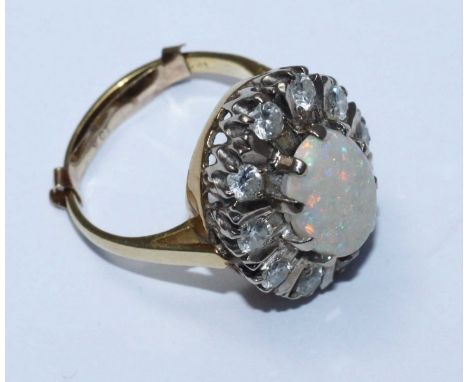 An 18ct gold, diamond and opal cluster dress ring, oval opal surrounded by ten RBC diamonds, estimated diamond weight 0.70 ca