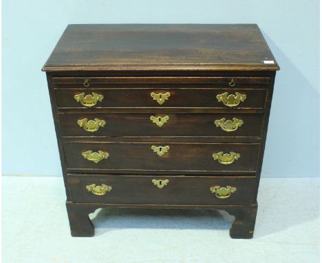 A small 18th century mahogany veneered chest of four long, graduated oak lined drawers, with brushing slide, brass pulls and 