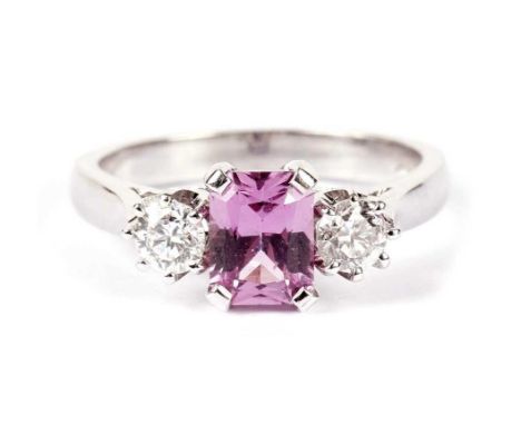 A pink sapphire and diamond ring, the central radiant-cut pink sapphire weighing approximately 0.90 carats, flanked by brilli