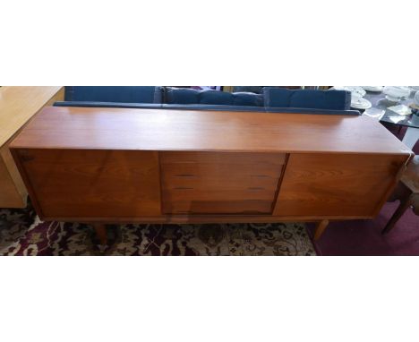 A mid 20th century Dyrlund Danish teak sideboard, with two sliding doors enclosing five central drawers, flanked by shelf spa