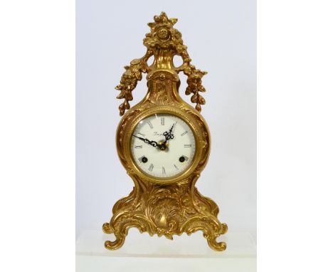A gilt metal mantel clock, the white dial signed Imperial and bearing Roman numerals, approximately 34 cm (h). [W]