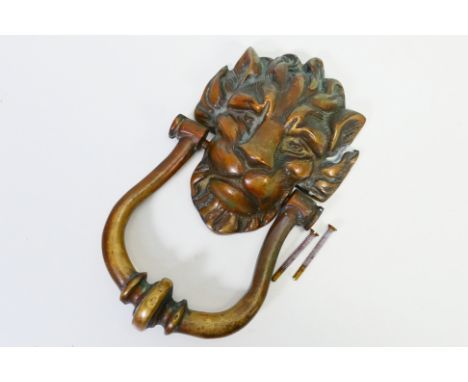 A cast brass lion mask door knocker, approximately 24 cm. [W]
