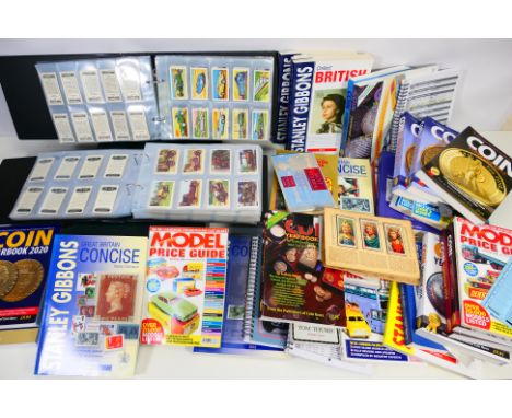 Two binders of cigarette / bubble gum and similar trade cards, a quantity of coin, stamp and model price guides / year books 