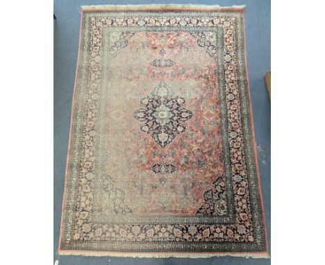 An Indian cotton carpet of ivory &amp; crimson ground, &amp; with all-over repeating foliate design within a multiple border 