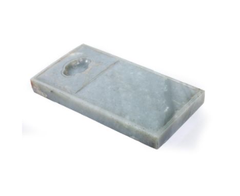 A Chinese spinach-green jade inkstoneQing dynasty, 18th centuryCarved in the form of a roof tile with a quatrefoil well at th