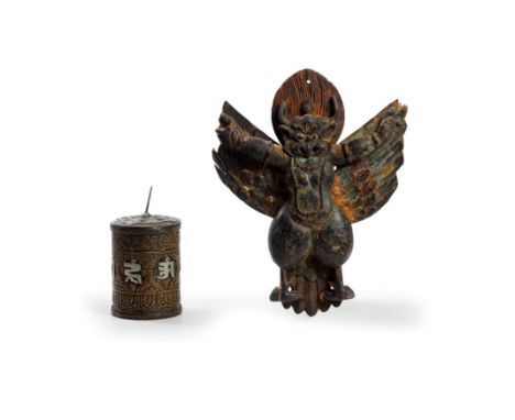 A painted wood figure of Garuda and a copper alloy repoussé prayer wheel with silvered inlay19th/20th centuryThe wooden figur