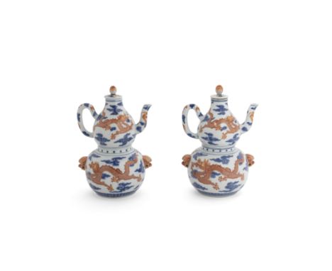 A pair of Chinese blue and white and iron-red double-gourd sectional wine warmers, ewers and coversMid-Qing dynasty, Yang he 