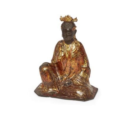 A Chinese lacquered bronze figure of Guanyin17th/18th centuryCast seated in elegant pose, her right hand resting on her knee,