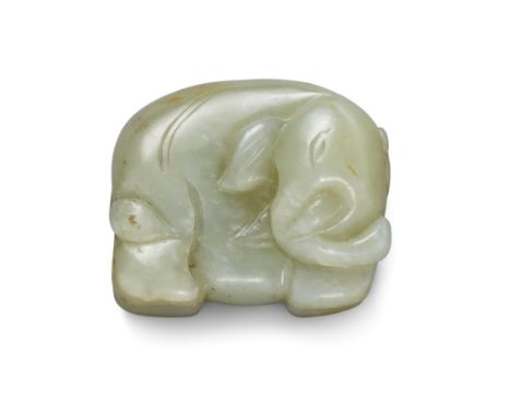 A Chinese green and russet jade elephantLate Qing dynastyThe standing animal carved from a green stone with cloudy white incl