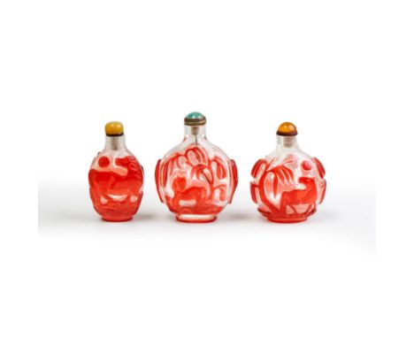 Three Chinese red overlay translucent glass 'horses' snuff bottlesQing dynasty, 19th centuryOne carved with horses under will