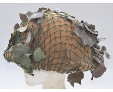 WW2 era British Army MkIV Turtle helmet with liner and camouflage netting. No markings visible 