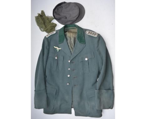 Two wartime German uniform jackets, a shirt, 2 caps and a leather belt (no sizes present). Complete with a mannequin for disp