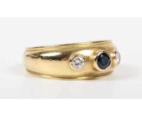 An 18ct gold, sapphire and diamond ring, the tapered band set with a circular cut sapphire between two circular cut diamonds,