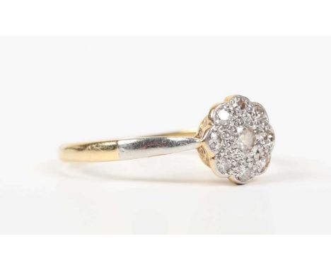 A gold, platinum and diamond nine stone cluster ring, mounted with the principal diamond at the centre, detailed ‘18ct Fine P