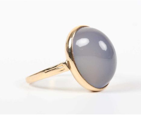 A gold ring, collet set with an oval cabochon pale blue stained chalcedony, unmarked, weight 4.8g, ring size approx N1/2.