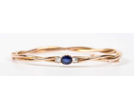 An Austro-Hungarian gold, sapphire and diamond oval hinged bangle in a twist design, the front mounted with a oval cut sapphi
