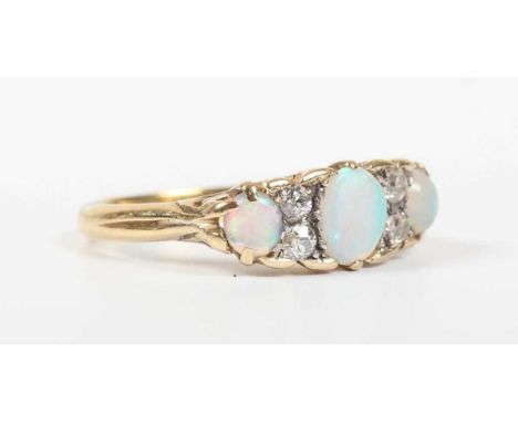 A gold, opal and diamond ring, mounted with three opals alternating with two pairs of old cut diamonds, the mount decorated w