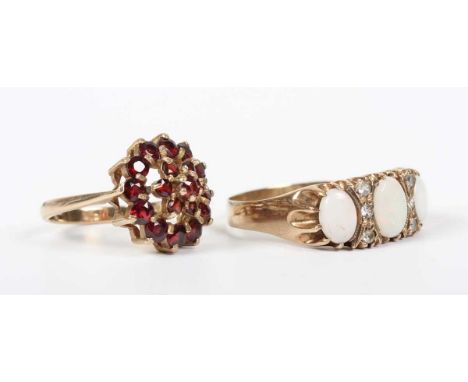 A 9ct gold, opal and colourless gem set ring, mounted with three oval opals alternating with two rows of three colourless gem