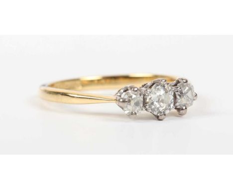 A gold, platinum and diamond three stone ring, claw set with a graduated row of old cut diamonds, detailed ‘18ct &amp; Pt’, w