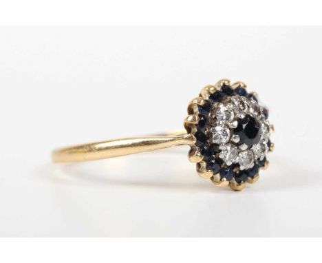 An 18ct gold, sapphire and diamond cluster ring, mounted with the principal sapphire within a surround of eight circular cut 