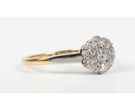 A gold, platinum and diamond cluster ring, mounted with the principal circular cut diamond at the centre, detailed ‘18ct &amp