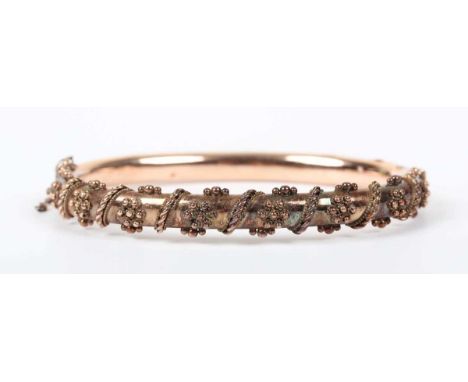 An Edwardian 9ct gold oval hinged bangle with applied bead and ropetwist wirework decoration, on a snap clasp, Birmingham 190