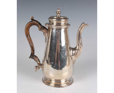 A George II silver coffee pot of tapering cylindrical form with domed hinged lid and knop finial above a foliate scroll spout