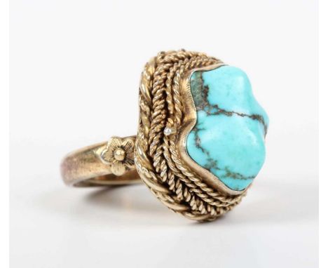 A Chinese silver gilt and turquoise ring, the hinged bezel opening to reveal a carved orange hardstone Buddha, otherwise with