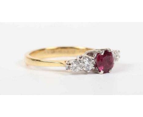 An 18ct gold, ruby and diamond ring, claw set with the cushion shaped ruby between four circular cut diamonds, import mark Sh
