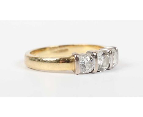An 18ct gold and diamond three stone ring, mounted with a graduated row of three circular cut diamonds, detailed ‘.75’, weigh