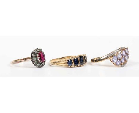 A gold, sapphire and diamond ring, mounted with five graduated oval cut sapphires and four pairs of diamond points at interva
