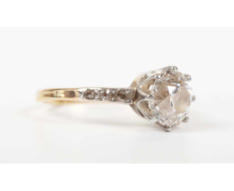 A gold and diamond ring, claw set with the principal old European cut diamond between diamond three stone shoulders, unmarked