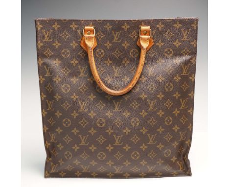 Classic Louis Vuitton Sac Plat tote crafted in signature monogram canvas with natural leather top handles and trim. Features 