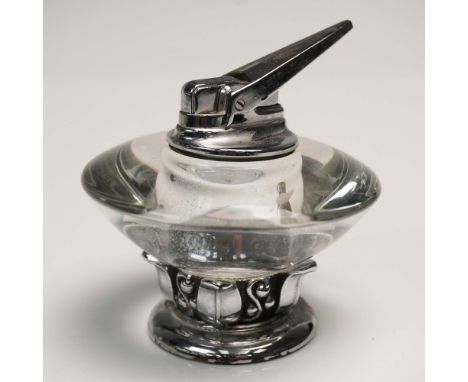 This vintage Ronson table lighter features a distinctive glass body with a sculpted chrome base and top assembly. The undersi