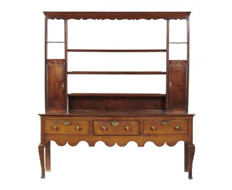 A GEORGE III OAK DRESSER, 18TH/EARLY 19TH C, with a rack with shaped doors to the spice cupboards, the base with three moulde