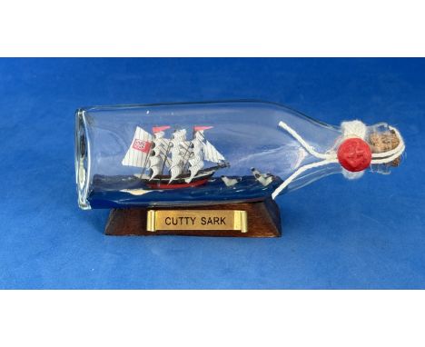 Cutty Sark Ship in a Bottle 5" Long 2.5" Tall appx. Great Model of the Cutty Sark glass bottle on stand. Good condition. We c
