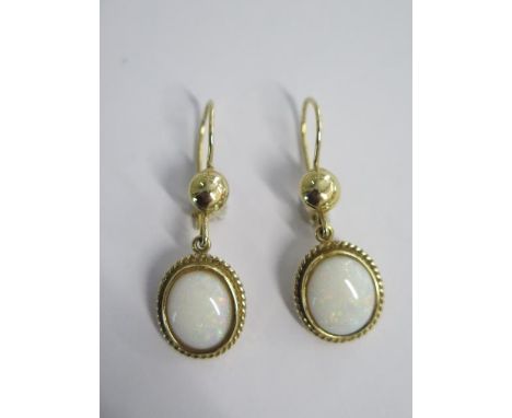 A pair of drop cabochon opal earrings in 18ct gold with safety wires - approx weight 8.9 grams - opals approx 12mm x 10mm - g