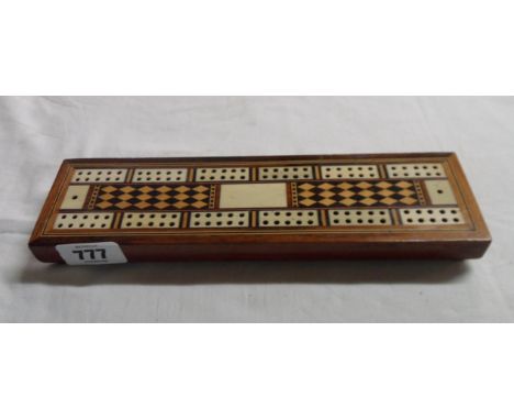 An old cribbage board with decorative ivory, rosewood and boxwood inlay and stringing with slide compartment beneath containi