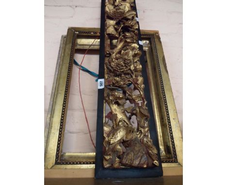 An antique Chinese deep reticulated carved wooden panel depicting birds amidst large blossoms with gilt finish and ebonised f
