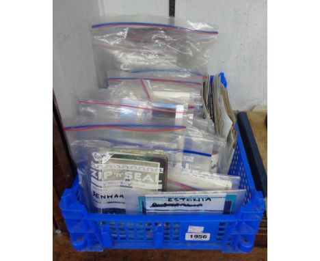 A crate containing a collection of vintage and modern world postcards in named bags, also other loose examples, etc.