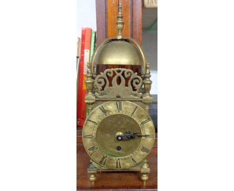 An antique brass lantern clock case with adapted battery movement and replacement hands