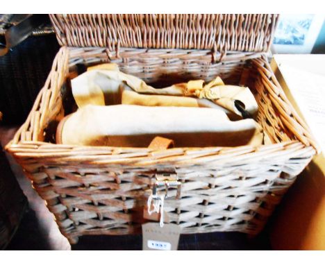 A vintage wicker fishing basket containing a vintage Brady canvas fishing bag and another