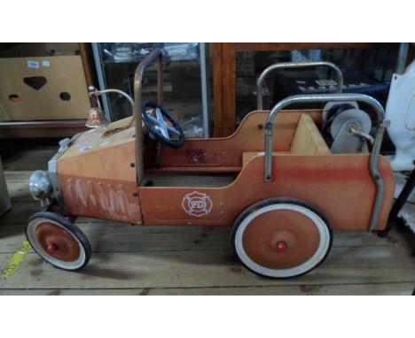 A vintage pedal car in the form of a fire engine