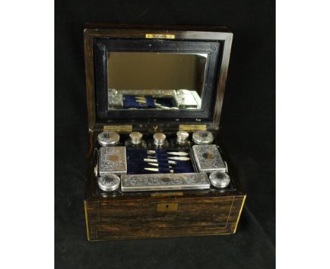 A Victorian coromandel travelling vanity box
The hinged cover lifts to enclose mirror and ten silver-plated topped jars and b