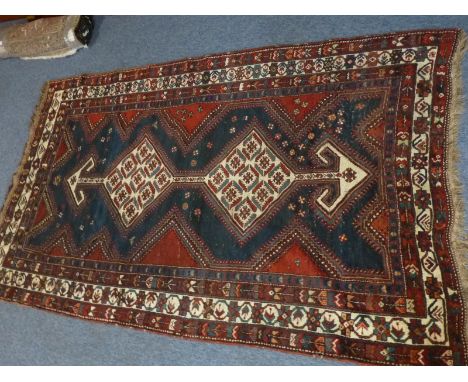 A hand knotted Eastern Rug, the two cream lozenges headed by arrow heads style motifs within a cobalt blue ground, within blu