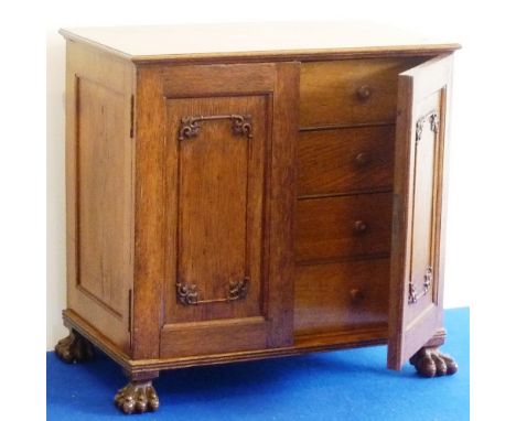 A 19th Century Chinese oak table cabinet, the two panelled doors displaying carved foliate-style spandrels and opening to rev