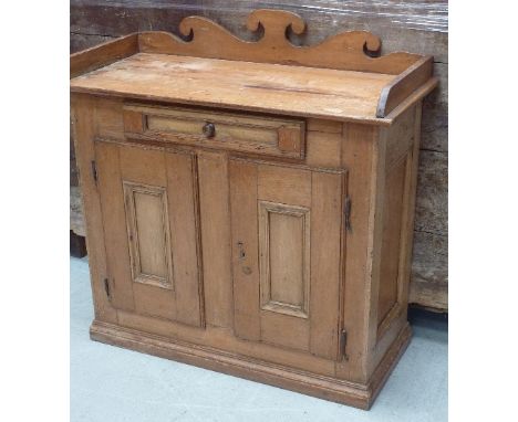 An unusual mid-19th century French Canadian pine Side Cabinet, the three-quarter galleried overhanging top above a single cen