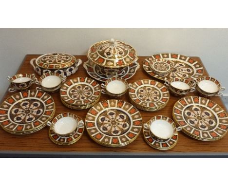 A large and fine Royal Crown Derby Dinner Service, each piece hand gilded and decorated in the 1128 Imari pattern, comprising